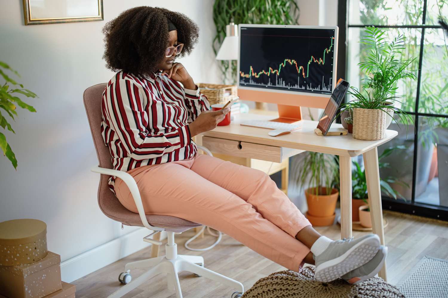 Woman entrepreneur analysing a cryptocurrency market graph at home office