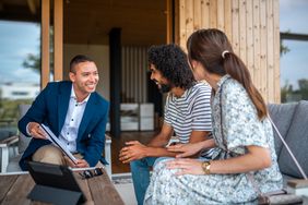 Insurance agent consulting a couple about suitable insurance policies for their situation.