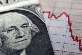 A dollar bill on top of a red trend line