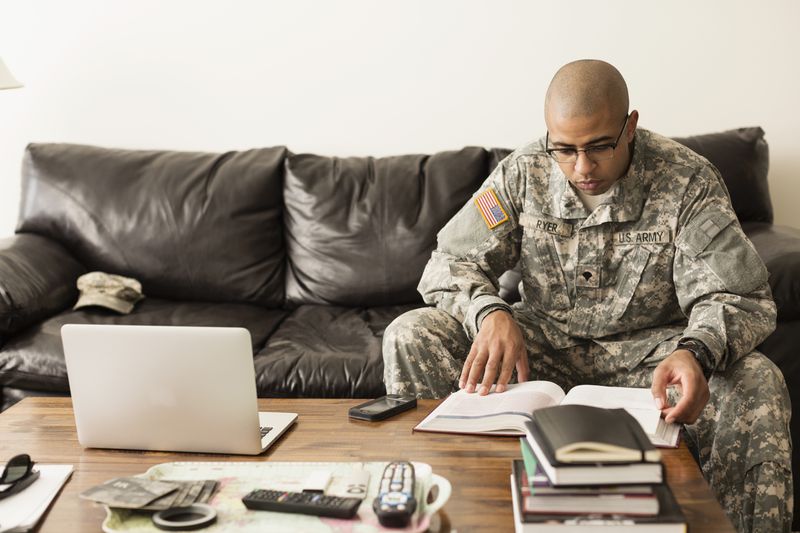 Soldier in fatigues studying on sofa