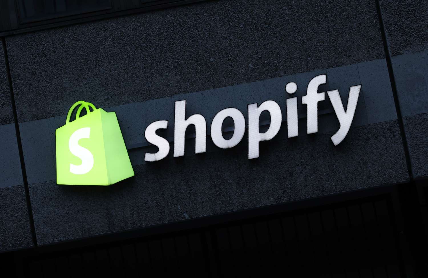 The corporate logo of e-commerce company Shopify hangs at the building that contains the offices of Shopify Commerce Germany GmbH on December 14, 2023 in Berlin, Germany