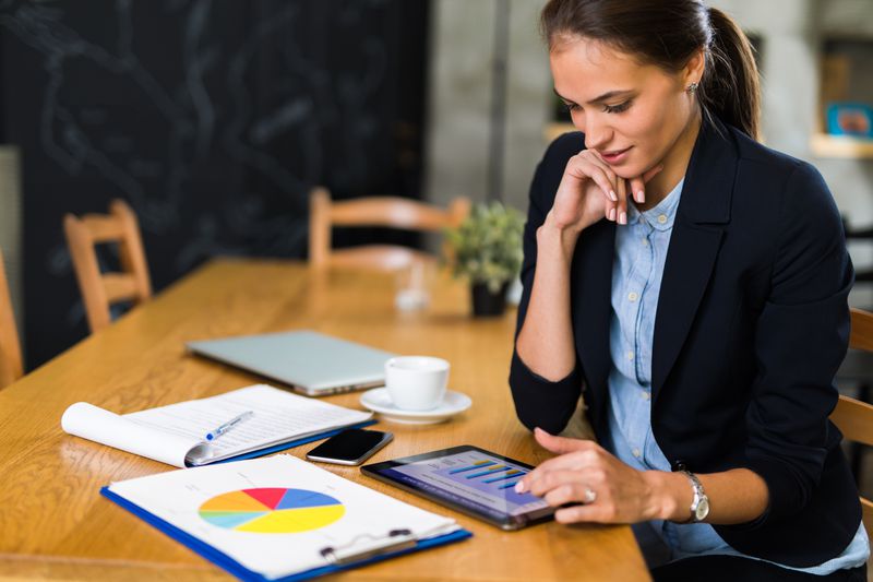 An investor sits at a table and reviews various charts