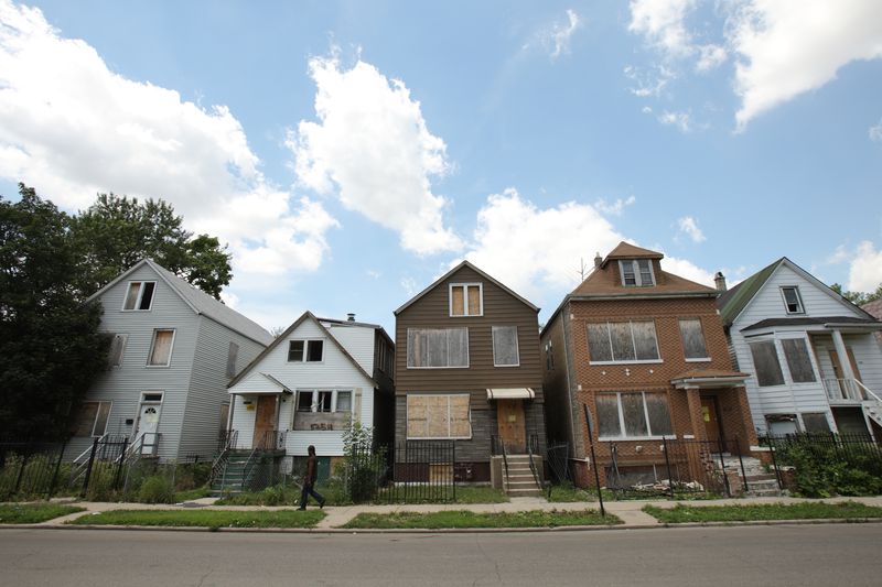 A man walks past five foreclosed homes in Chicago on July 21, 2010.