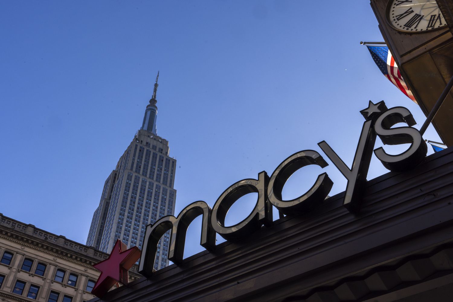 The Empire State Building behind a Macy's logo in New York City.