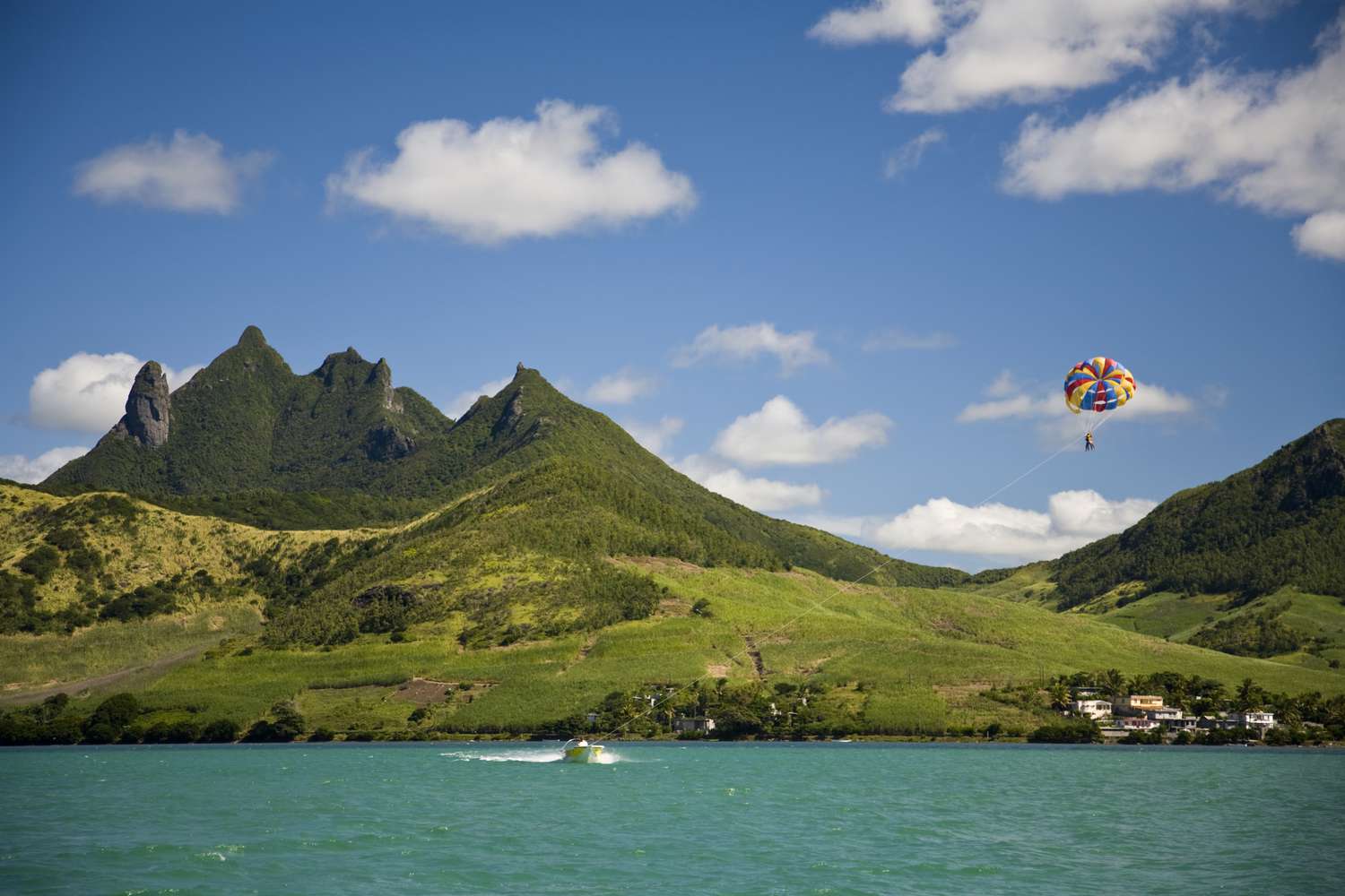 MR tourist on Parasail with view of Lion Mountain, South East Mauritius, Africa.