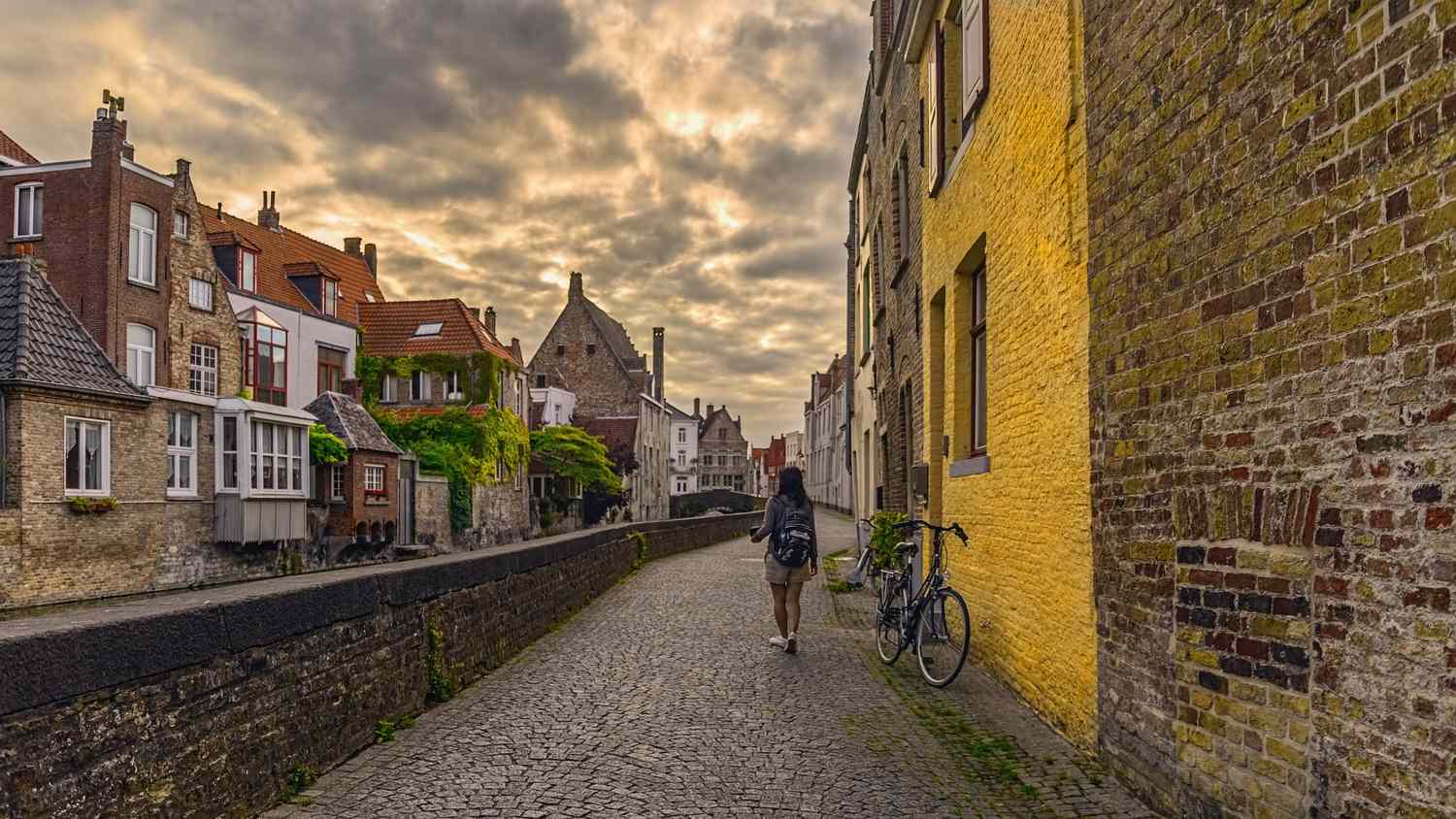 Woman walking down a cobblestone street in Bruges, Belgium