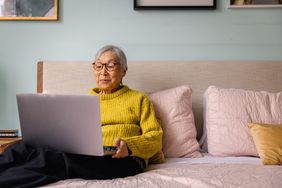 An older person uses a laptop.