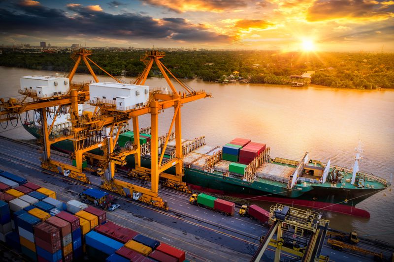 Large cranes unloading a container ship at a port.