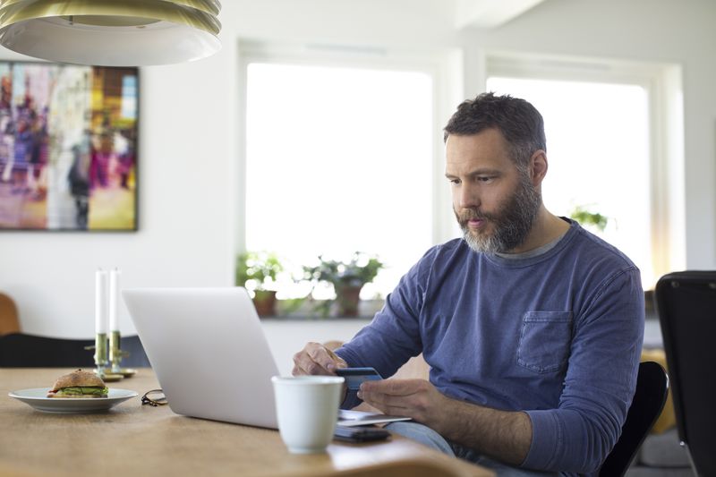 A man uses a credit card shopping online.