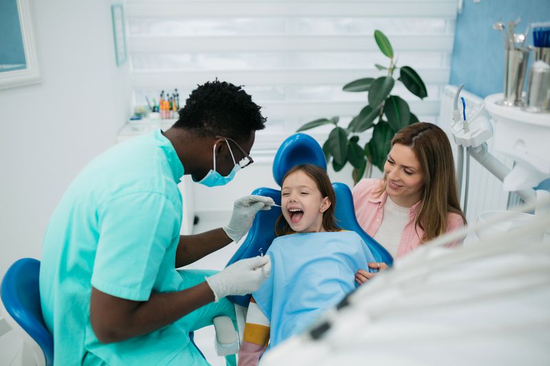 A dentist examines a child's teeth.
