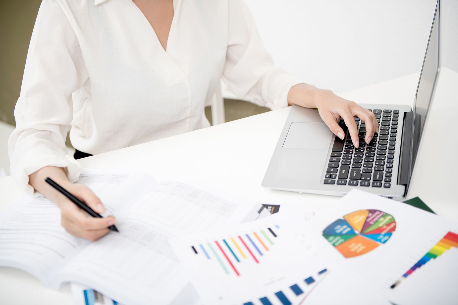 Businesswoman Analyzing Investment Charts with Laptop