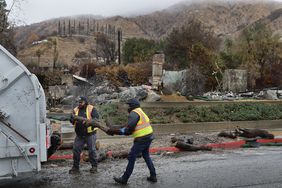 Crews remove downed trees blocking the gutter as they prepare for flooding and debris flow in the rain in the Eaton fire burn zone in Altadena Thursday, Feb. 13, 2025