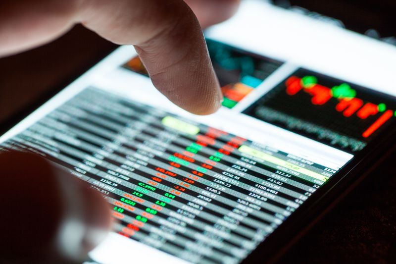 A person using smartphone to check the prices of Nasdaq stocks.