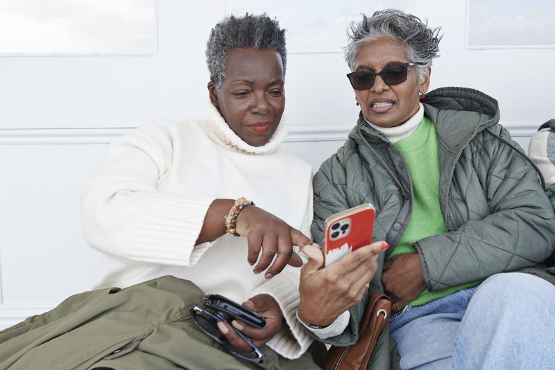 Two older women look at smartphone
