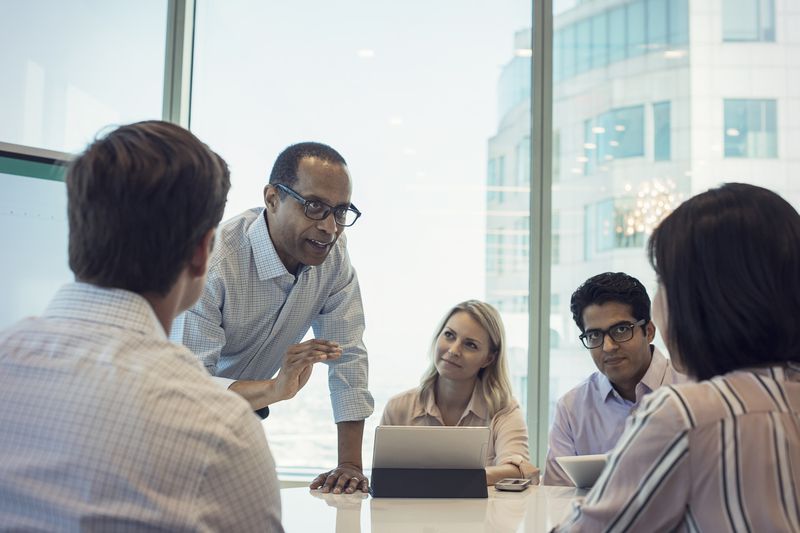 Executive MBA (EMBA) students meet with a professor.