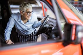 A woman inspects a car.