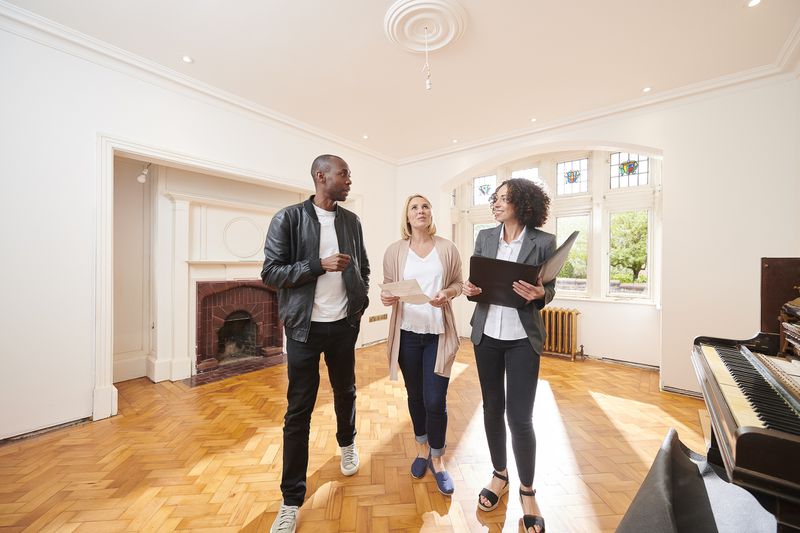An estate agent shows a couple around a refurbished period home