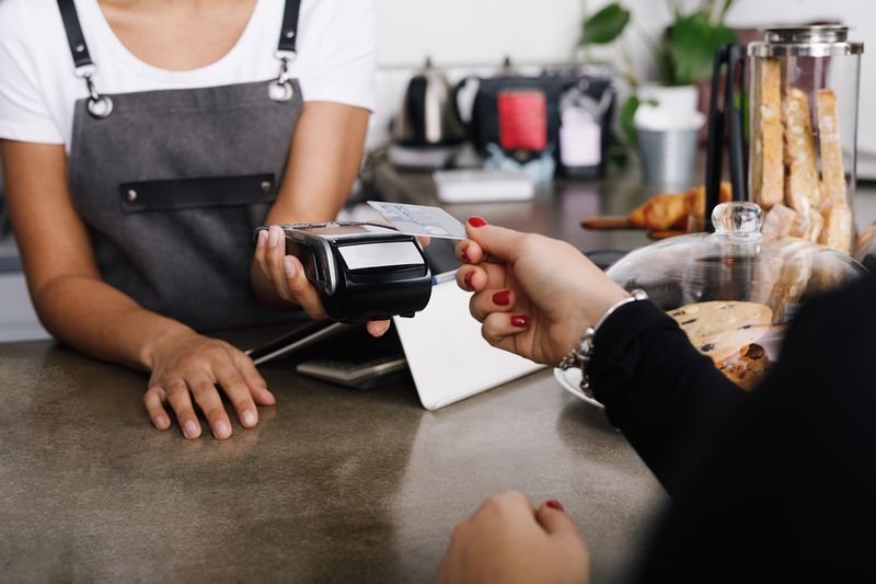 Woman Hand Holding Credit Card While Making Payment In Cafe