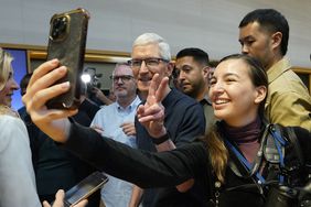 Apple CEO Tim Cook poses with customers during Apple's iPhone 16 launch in New York on Sept. 20, 2024