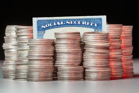 Close-up of coins stacked by social security card on table against black background.