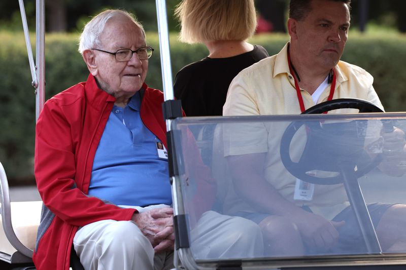 Warren Buffett being driven in a golf cart.
