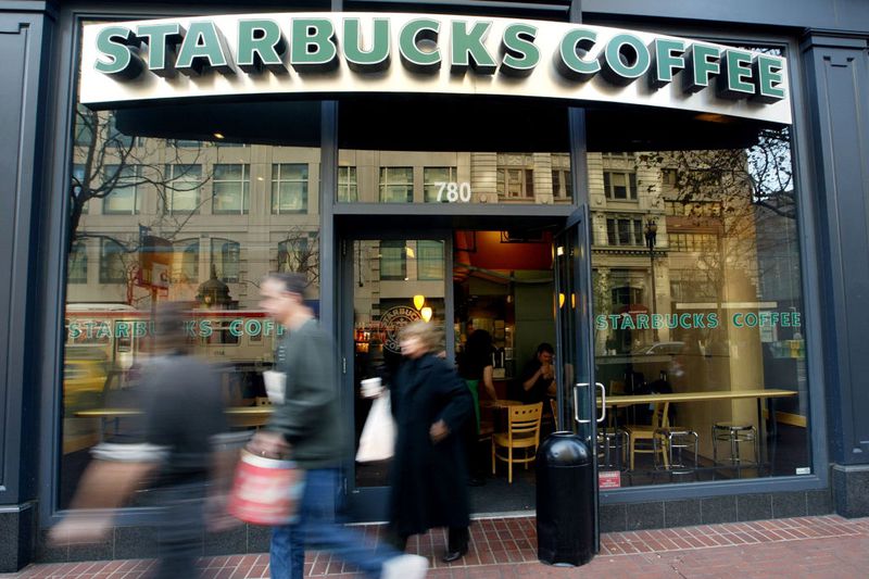 People walk out of a Starbucks coffee shop.