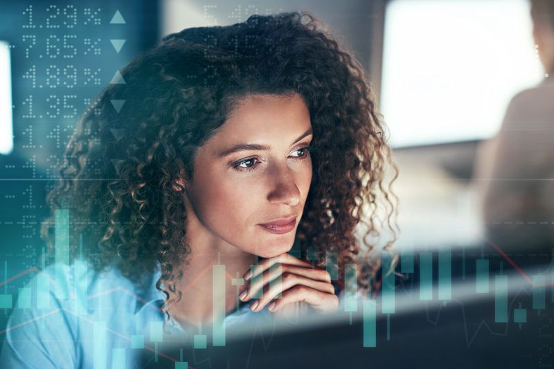 A trader looking at a computer screen with stock numbers overlaid
