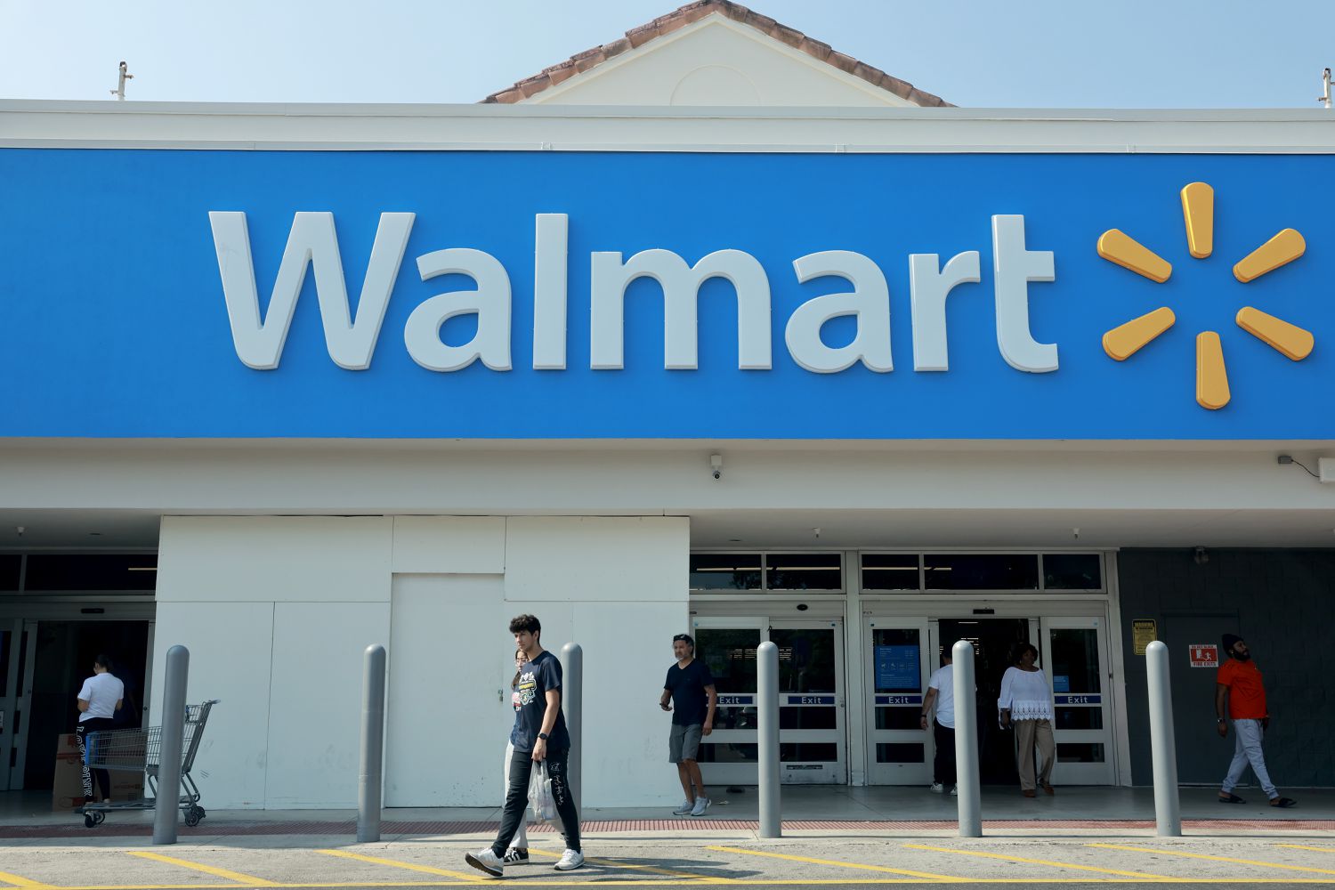 People walk near the entrance to a Walmart store on May 14, 2024 in Miami, Florida