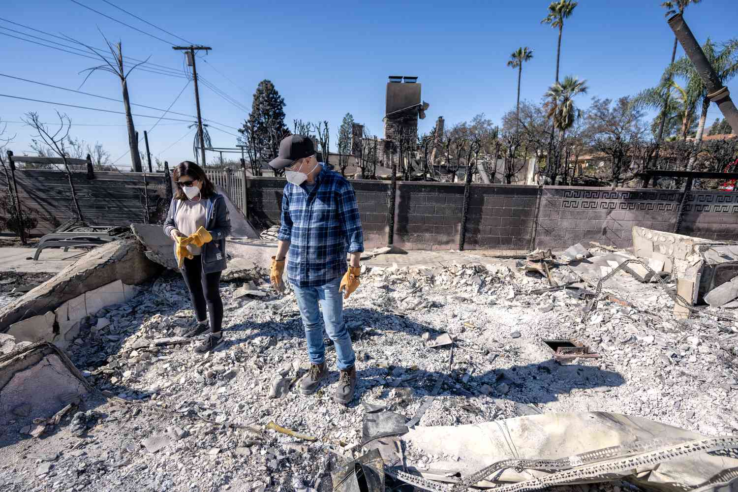 Darryl and Christine Montes look through the debris of their home on Valley Lights Dr in Pasadena on Thursday, January 16, 2025.