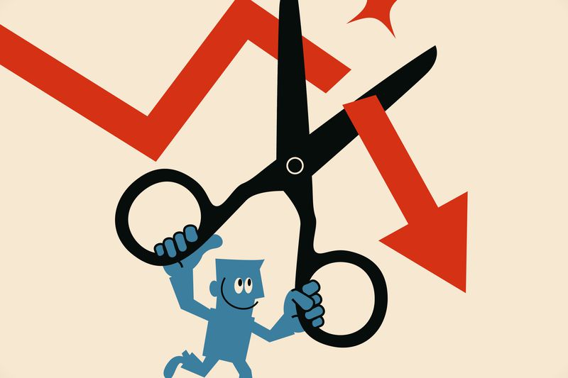 A man using scissors to cut off the falling downward arrow.