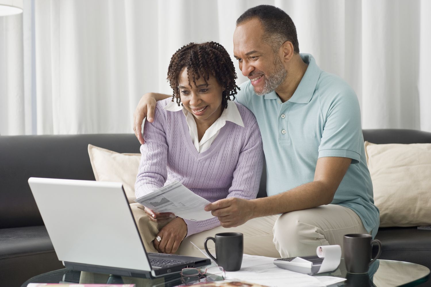Couple in their 40s sitting on their sofa and looking at mortgage rates online