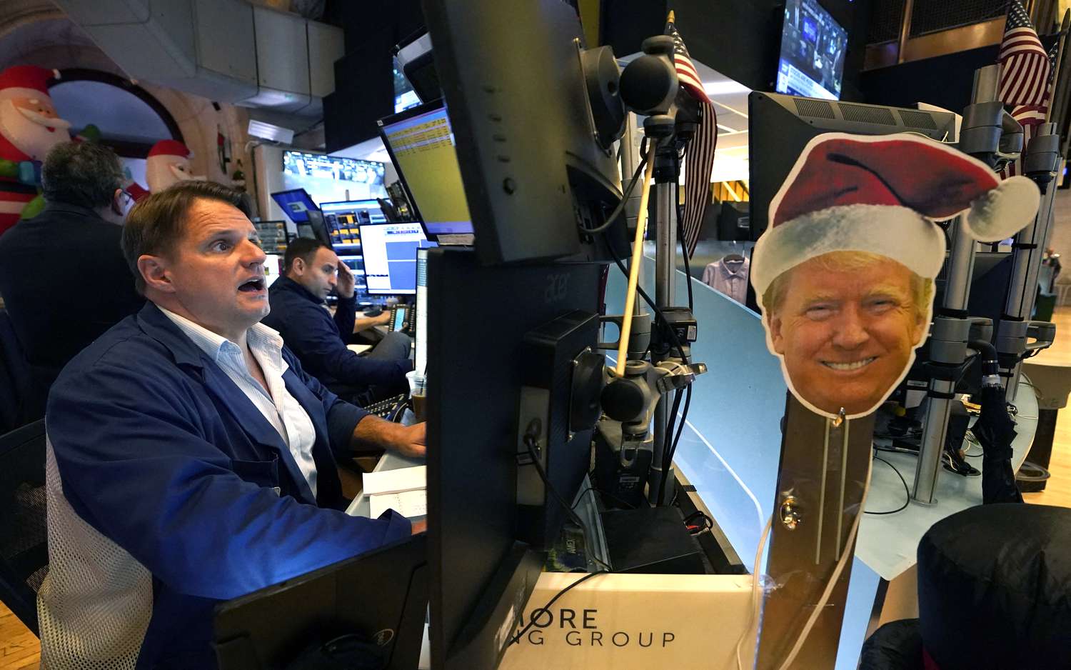 An image of US President-elect Donald Trump is displayed as traders and financial professionals work on the floor of the New York Stock Exchange