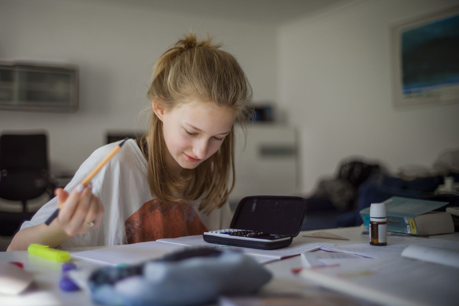 Girl with calculator and papers at desk