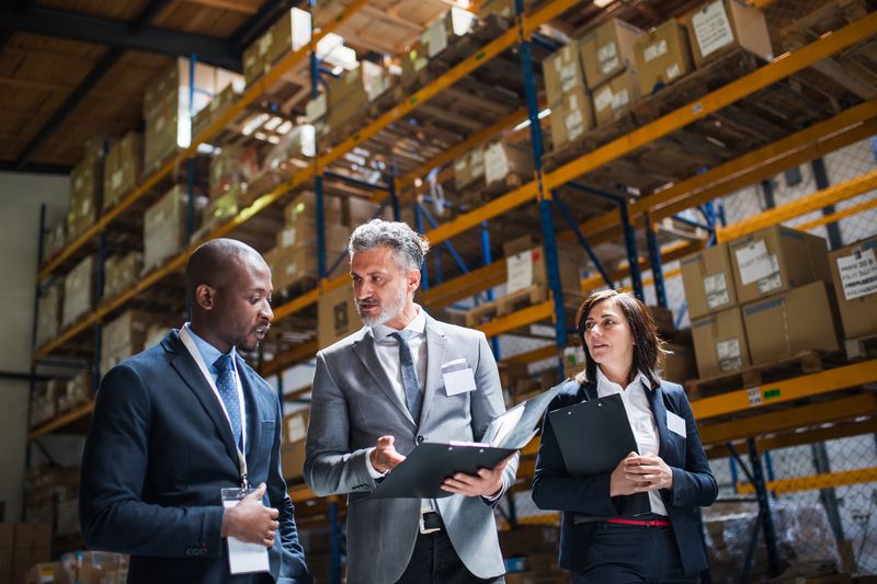 Business people discussing financing options inside a warehouse