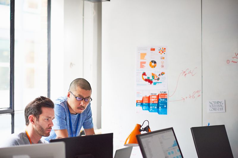 Two businessmen working together at the computer