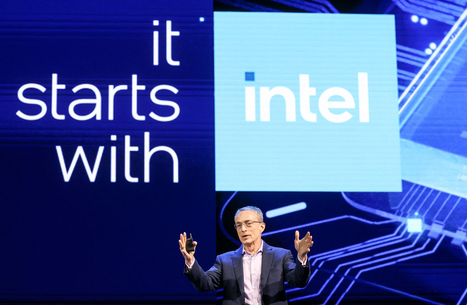Former Intel CEO Pat Gelsinger stands in front of a blue screen with the phrase "it starts with Intel" alongside the blue square Intel logo