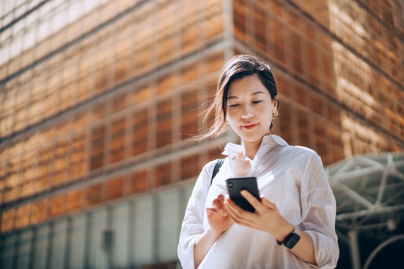Woman looking at her phone on the street