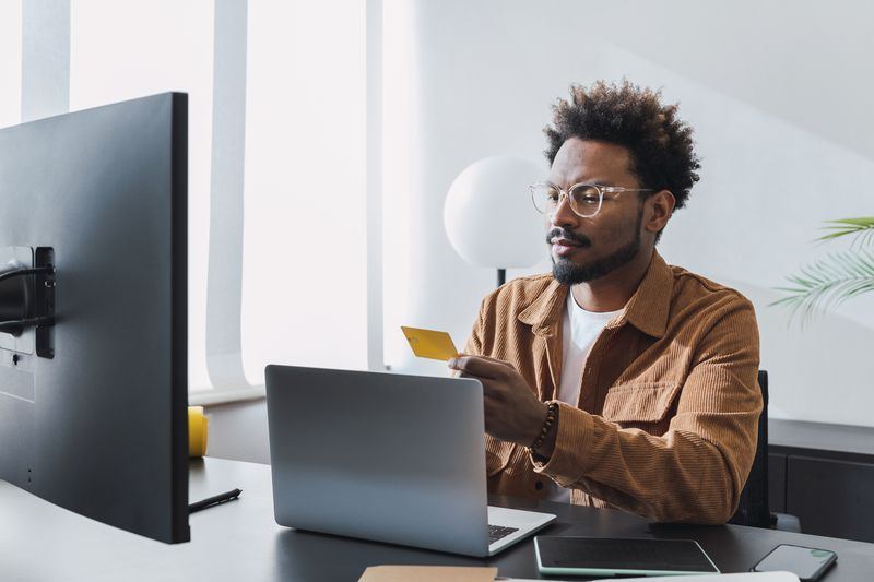A man shopping online with a credit card.