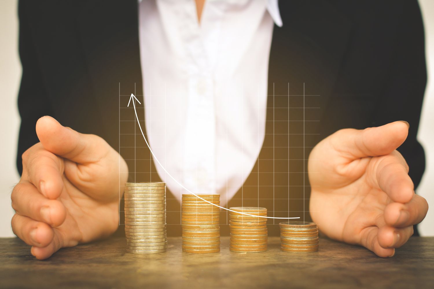 A rising bar graph over coins between hands