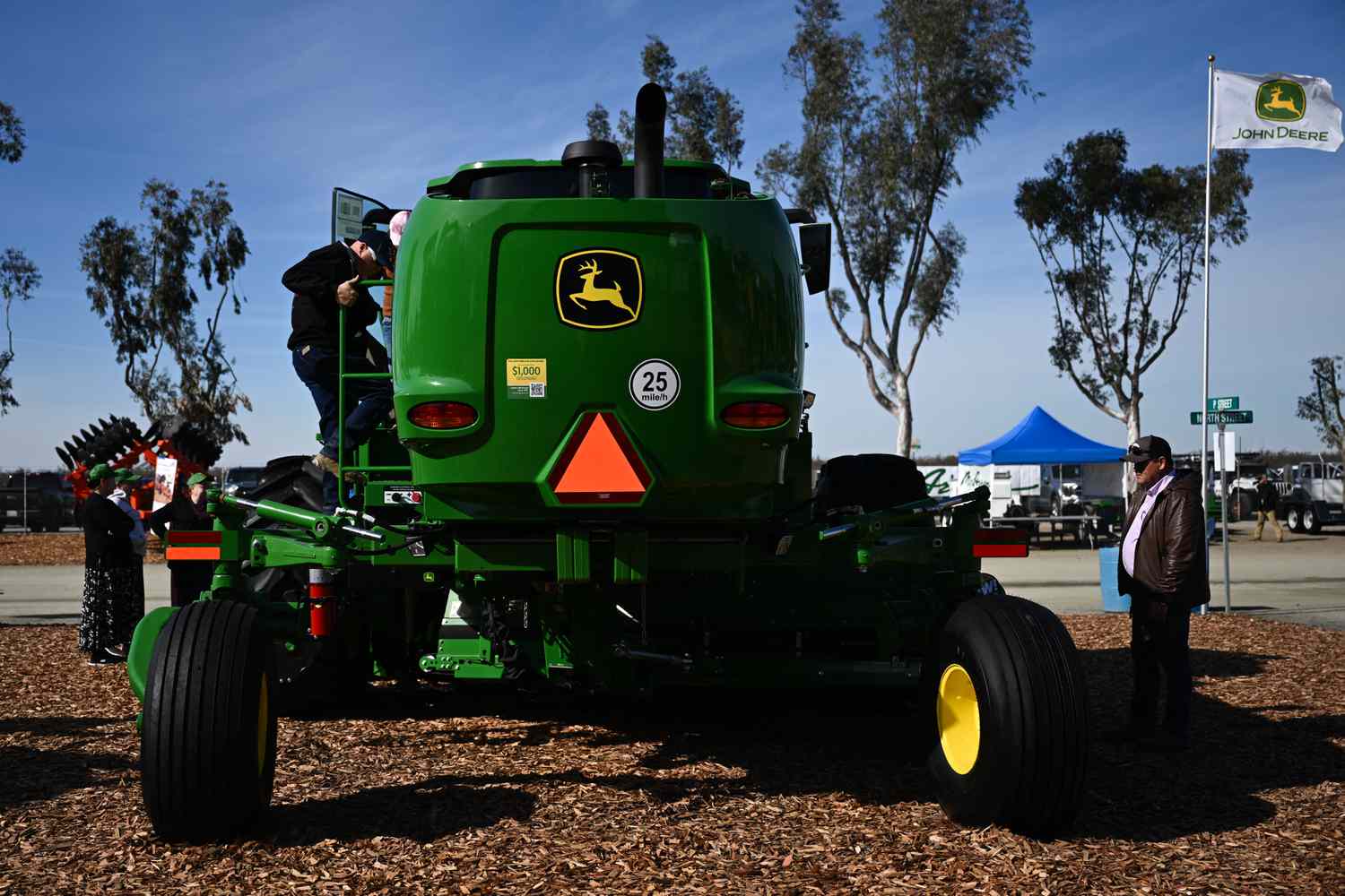 The John Deere logo is displayed as attendees view farm equipment at the Deere & Co. booth during the World Ag Expo at the International Agri-Center in Tulare, California on Feb. 11, 2025