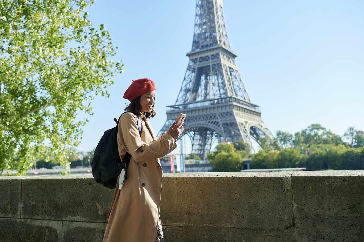 Woman walking using mobile phone with Eiffel Tower in the background