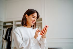 A woman uses a smartphone in a store.