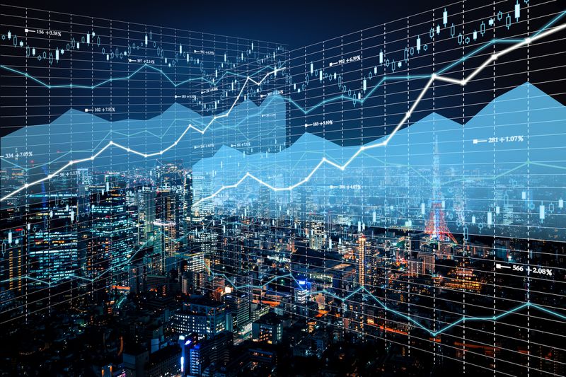 Financial line graphs overlaid onto a cityscape at night