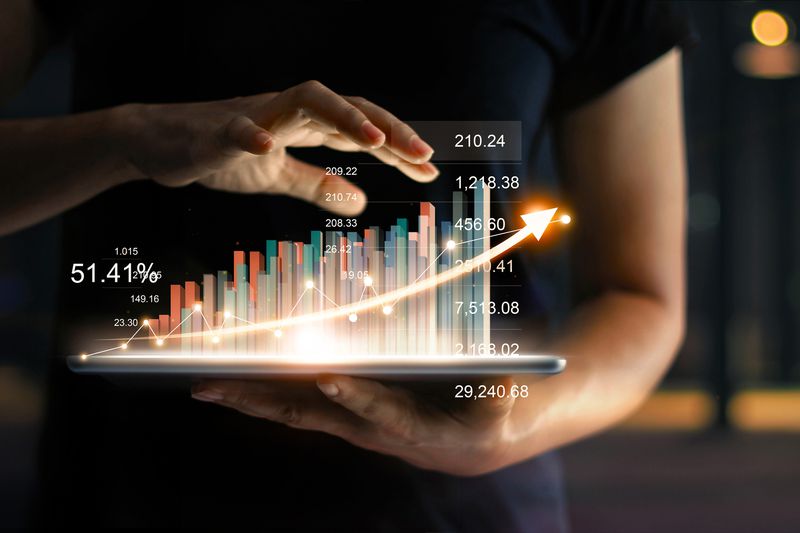 Cropped hands holding tablet with a 3D graphic of charts and bars emerging from it