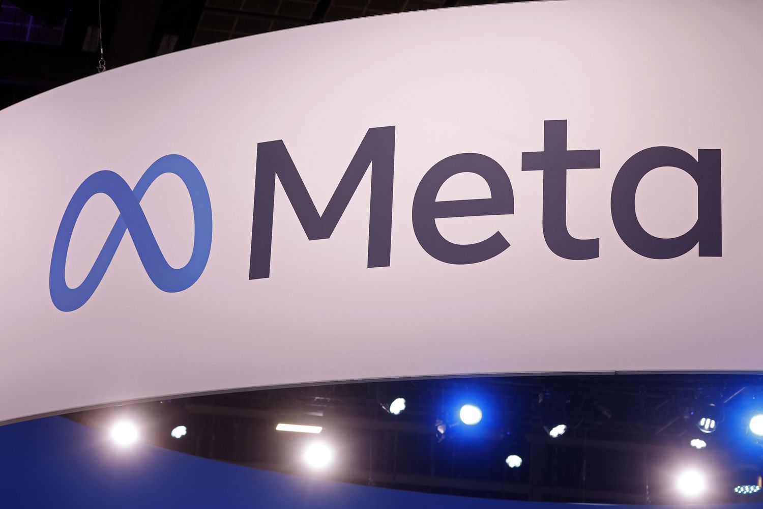 The Meta logo is displayed on a sign at a conference. 