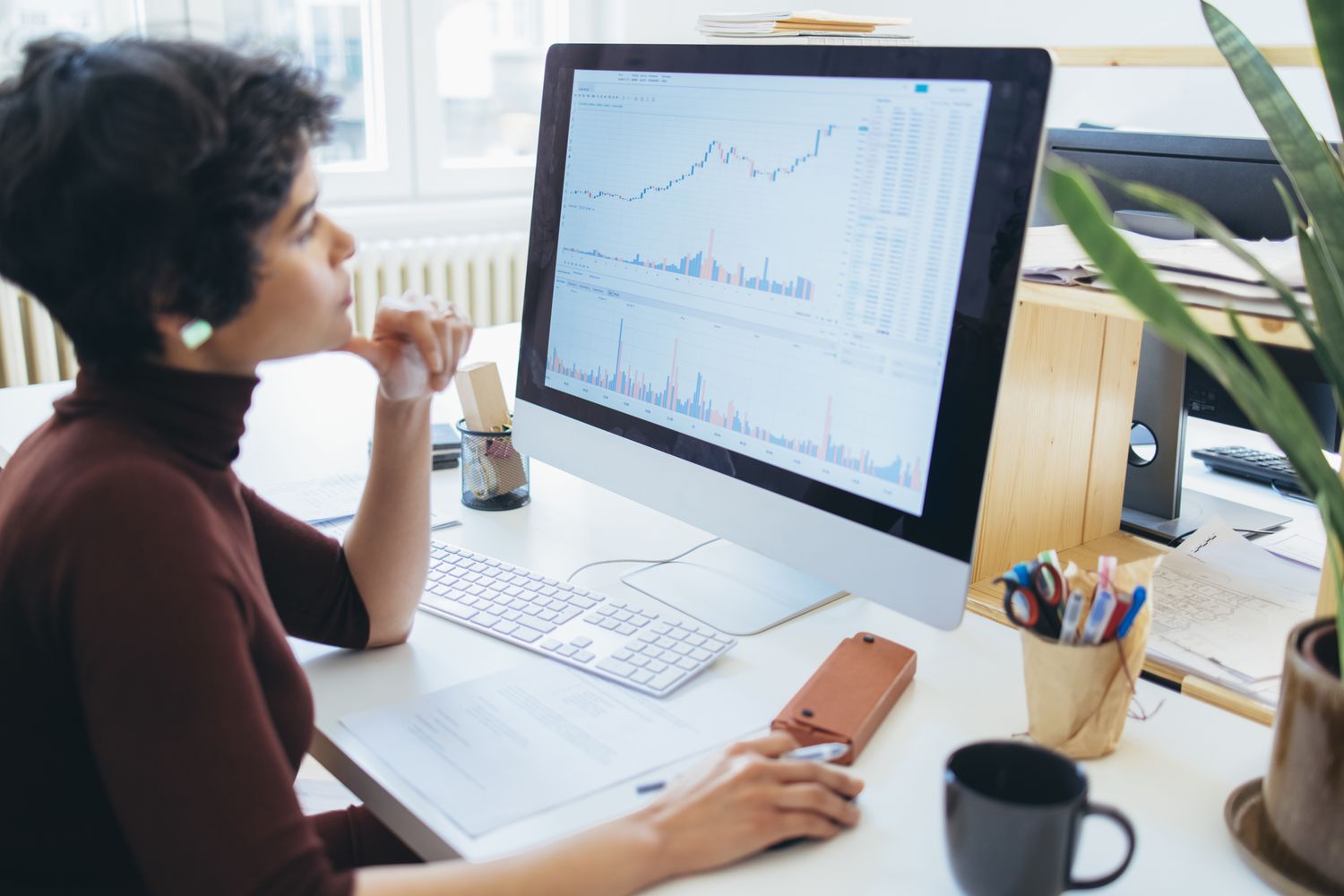 A person working at a computer and looking at stock data