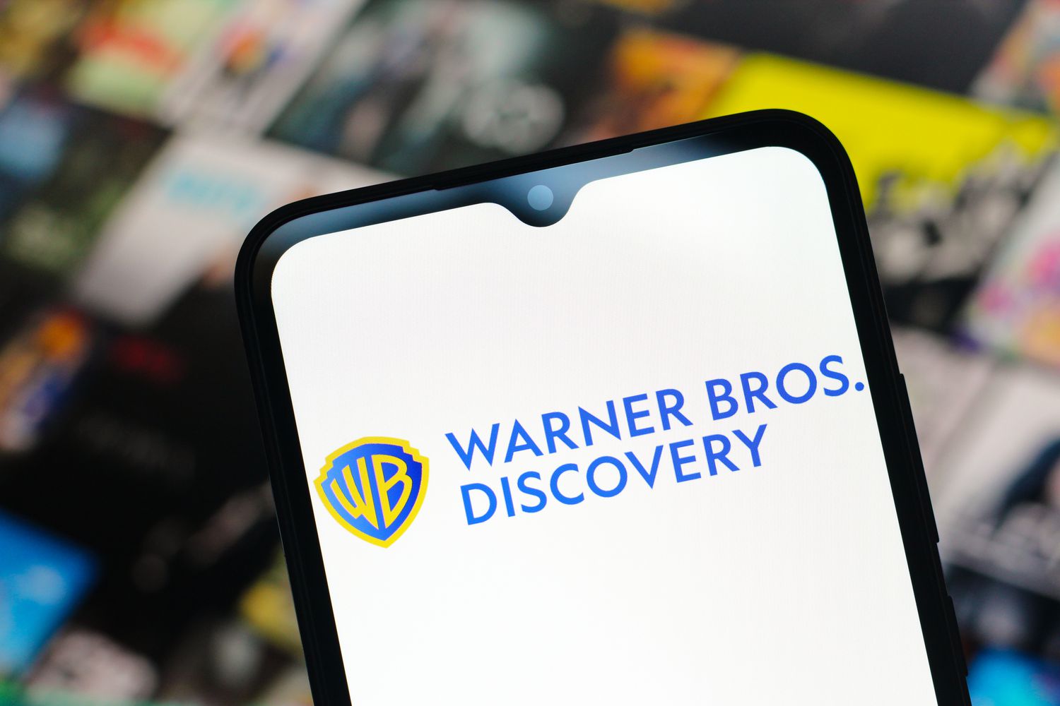 The Warner Bros. Discovery logo is seen displayed on a smartphone screen