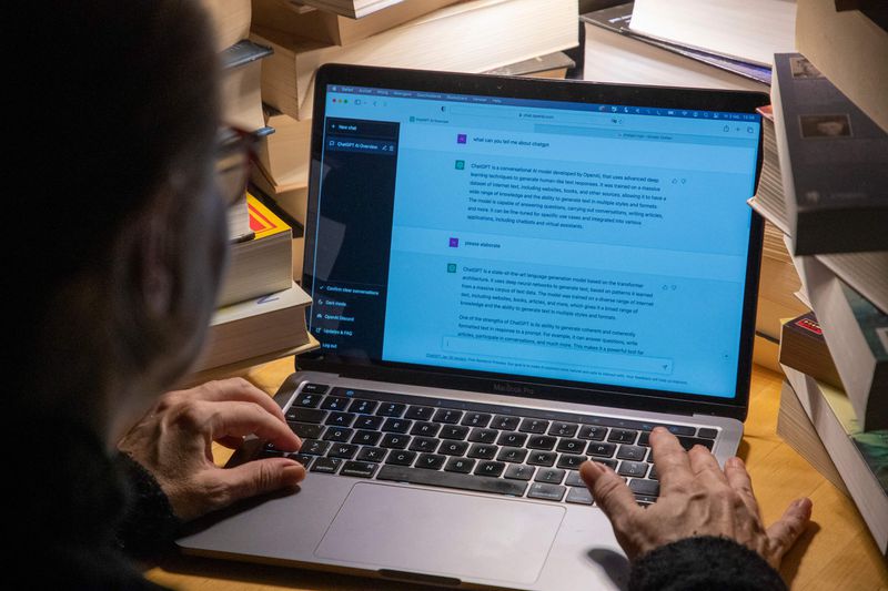 View from behind of a person typing on a computer using ChatGPT