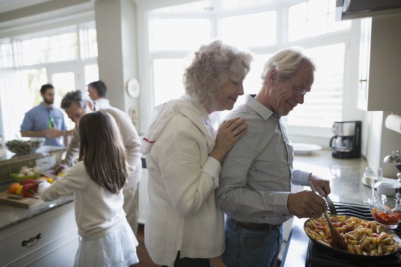 Senior couple cooking at kitchen stove
