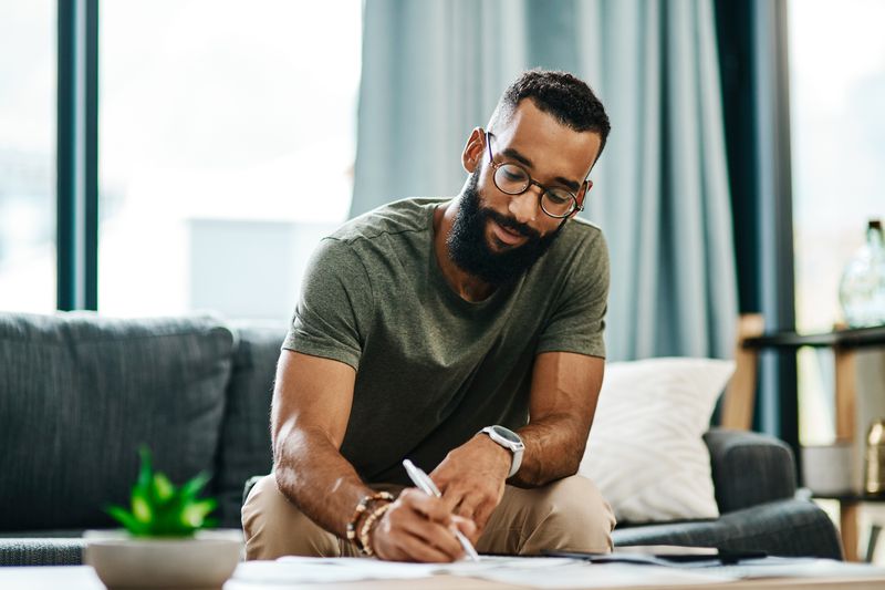 A man fills out paperwork for a credit union personal loan.